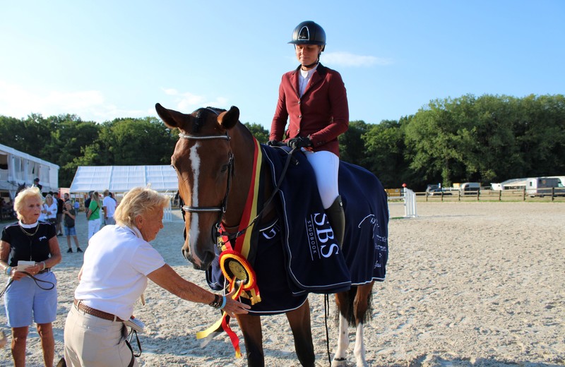 Nicole Bouillart rectifie l'écharpe de KANNAN DRY DB (Kannan x Balou du Rouet), 3ème chez les 6 ans sous la selle d'Odile Gierech (photo: C.R. - SBS)